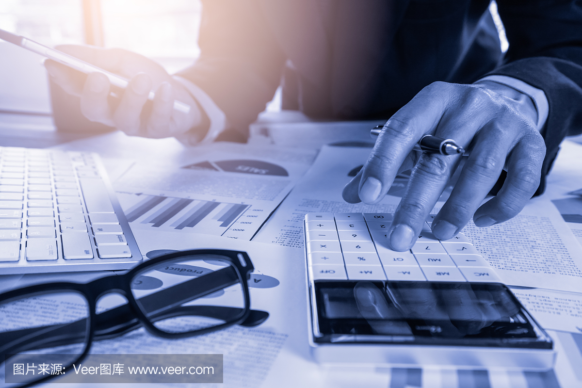 商人或会计工作计算器计算业务数据的概念。会计、投资顾问咨询财务报告的情况,并在办公室策划营销计划。